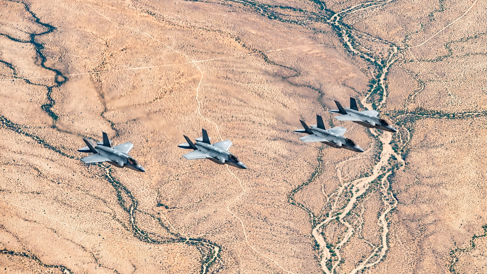 Four U.S. Air Force F-35A Lightning II aircraft assigned to the 56th Fighter Wing fly in formation over the Sonoran Desert