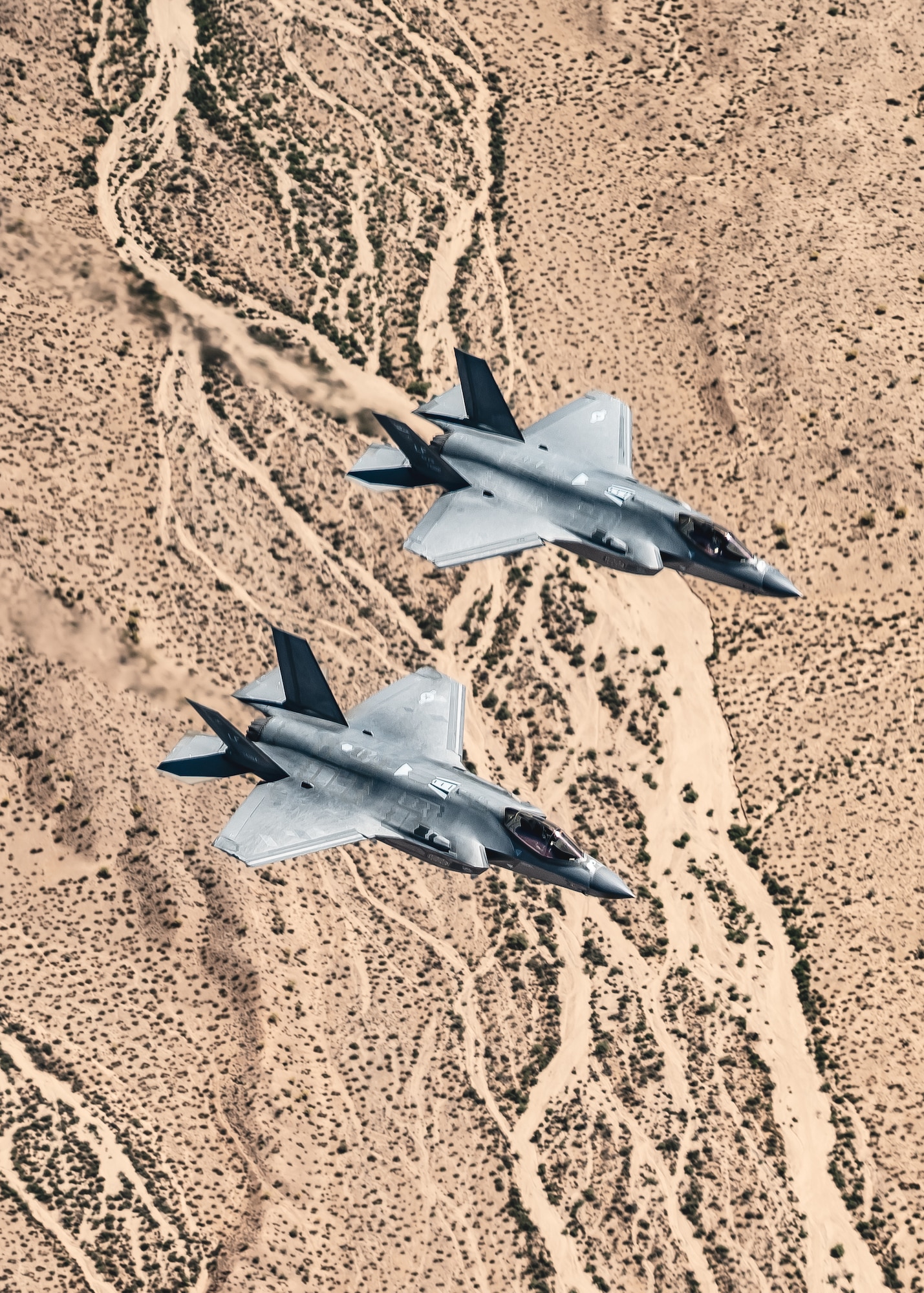 Two F-35A Lightning II aircraft assigned to the 56th Fighter Wing fly in formation over the Sonoran Desert