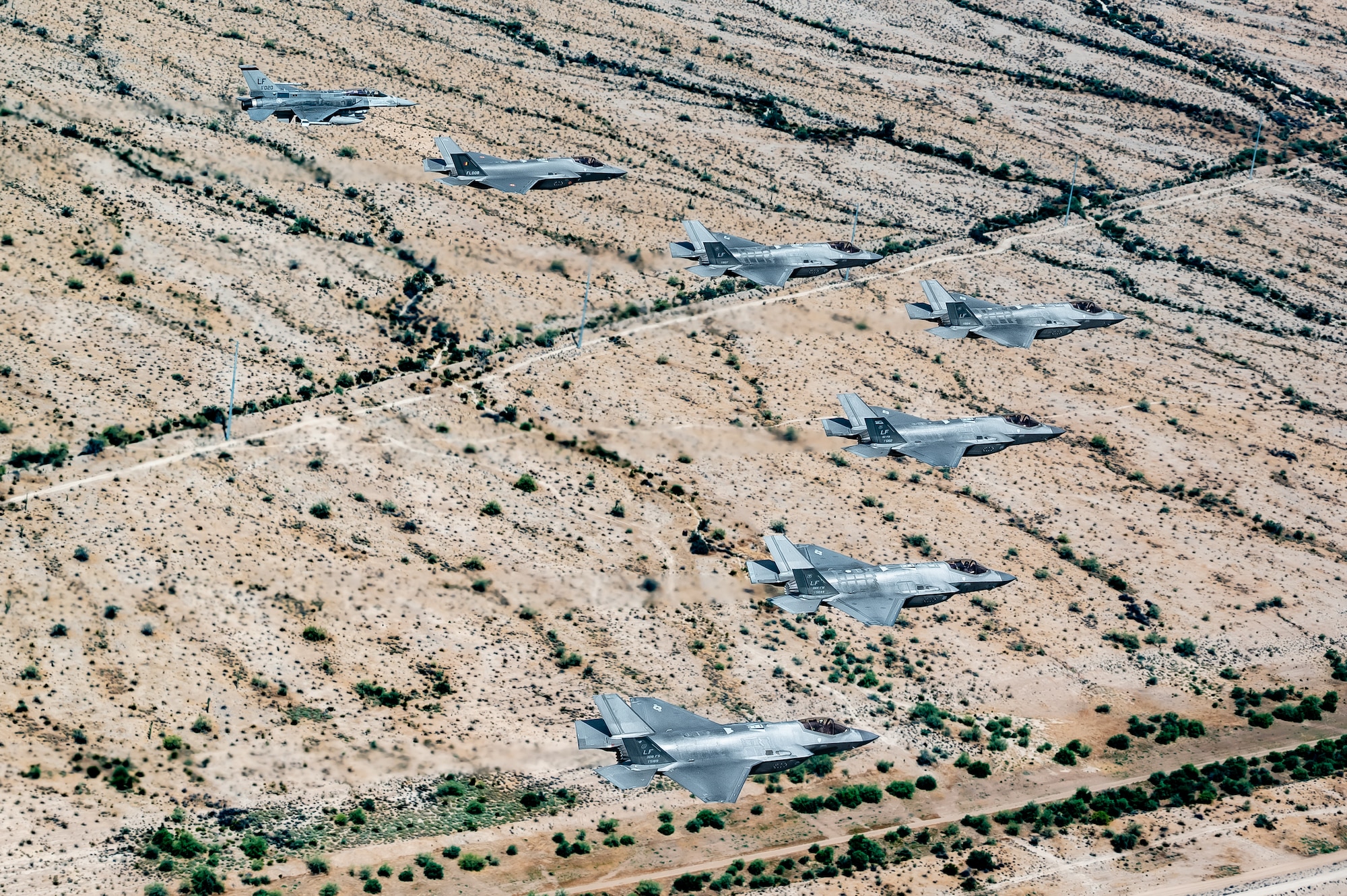 A Republic of Singapore Air Force F-16D Fighting Falcon, a Belgian Air Component F-35A Lightning II, and U.S. Air Force F-35A Lightning II aircraft assigned to the 56th Fighter Wing fly in formation over the Sonoran Desert