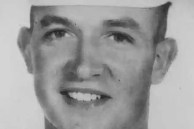 A man in a military dress uniform poses for a photo.