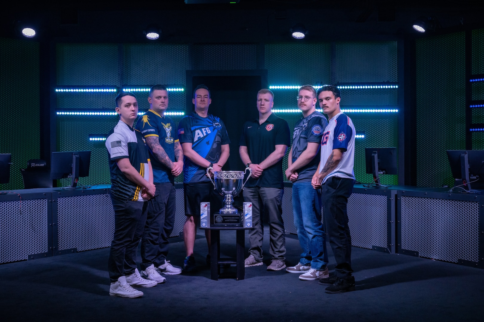 U.S. Service members pose beside a championship trophy before the 2026 Armed Forces Esports Championship at Localhost in Philadelphia Pennsylvania, April 23, 2026. Service members competed in organized esports competition playing Marvel Rivals for championship honors while representing their respective services. Armed Forces Sports brings together service members from the Army, Marine Corps, Navy, Coast Guard, Air Force, and Space Force to compete at the national level. Armed Forces Sports promotes physical fitness, cognitive readiness, teamwork, and competitive opportunities for military members while supporting recruitment and retention efforts and strengthening partnerships through emerging sports platforms. (DoW photo by U.S. Navy Mass Communication Specialist 2nd Class Christopher Suarez)