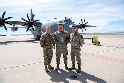 Airmen pose for a photo with their award.