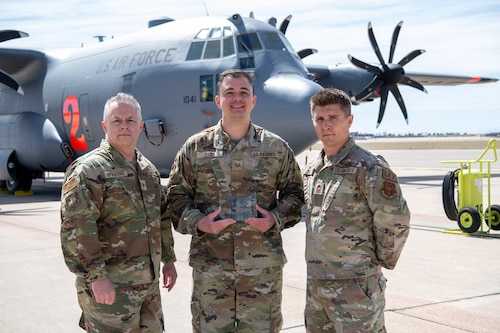 Airmen pose for a photo with their award.