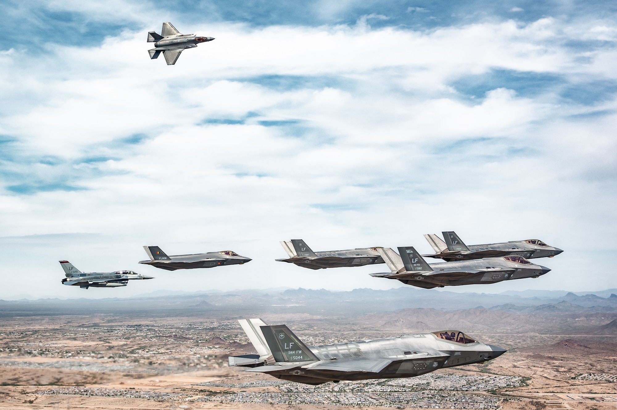 A Republic of Singapore Air Force F-16D Fighting Falcon, a Belgian Air Component F-35A Lightning II, and U.S. Air Force F-35A Lightning II aircraft assigned to the 56th Fighter Wing maneuver in formation
