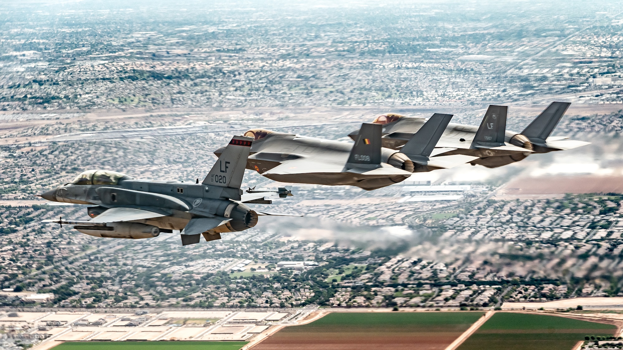 A Republic of Singapore Air Force F-16D Fighting Falcon, left, a Belgian Air Component F-35A Lightning II, middle, and a U.S. Air Force F-35A Lightning II, right, aircraft assigned to the 56th Fighter Wing fly in formation