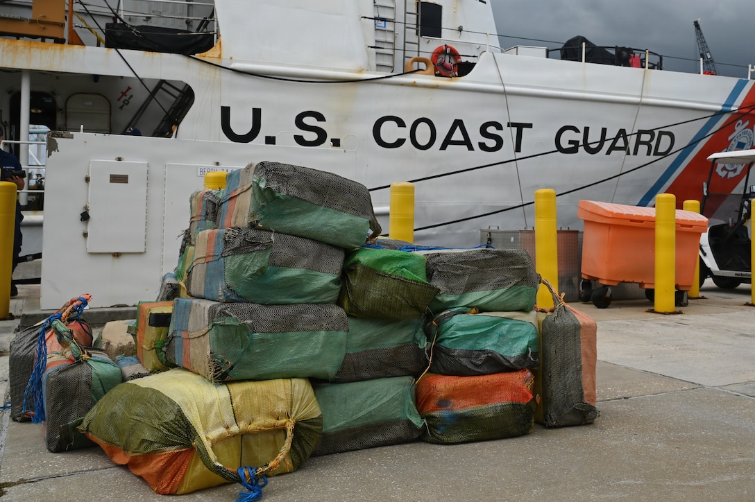 Bales of illicit drugs worth more than $19 million are stacked on a pier during a drug offload from USCGC Resolute (WMEC 620) at Base Miami Beach, Florida, April 23, 2026. The seized contraband was the result of three interdictions in the Caribbean Sea by the crew of the Coast Guard Cutter Tahoma and the crew of the USS Billings with an embarked Coast Guard law enforcement detachment. (U.S. Coast Guard photo by Petty Officer 3rd Class Reese Hindmarsh)