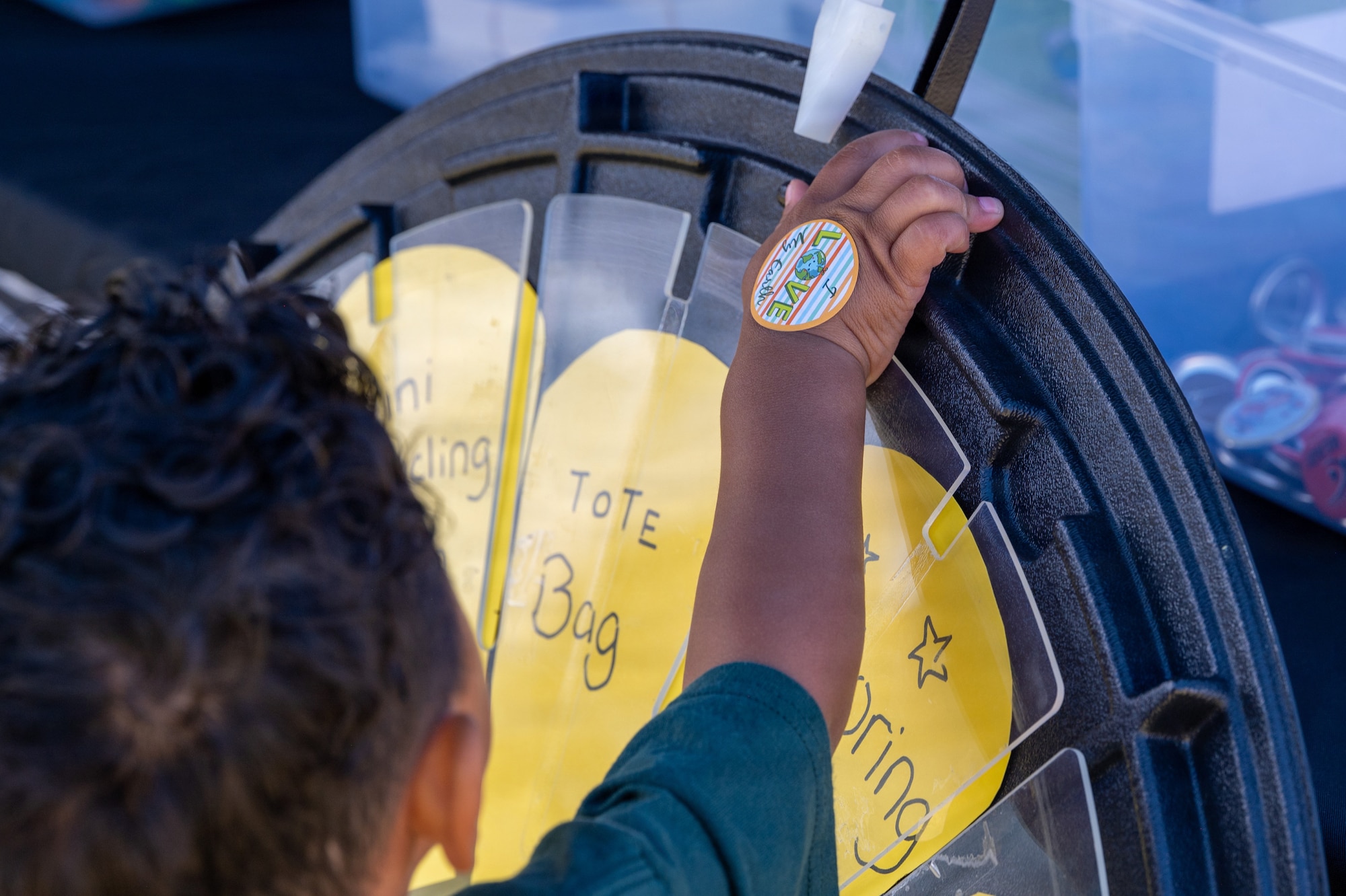 A child's hand spins a prize wheel