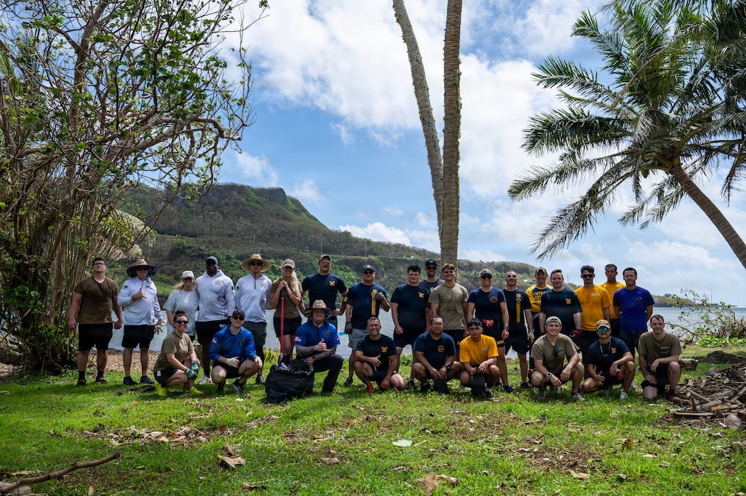 Sailors and civilians from Commander, Submarine Squadron 15 (CSS-15), pose for a group photo after participating in a beach cleanup following Super Typhoon Sinlaku. CSS-15 and other military commands across Guam are providing vital support to villages and civil authorities, strengthening crisis response and recovery efforts in the wake of Super Typhoon Sinlaku.
