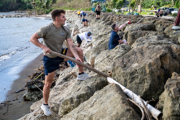 A Sailor assigned to Commander, Submarine Squadron 15 (CSS-15), participates in a beach cleanup following Super Typhoon Sinlaku