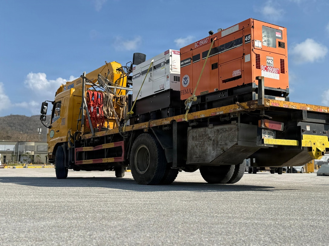 A truck with two generators loaded on the back.