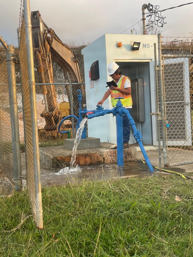 A man checks water flow from a pump station.