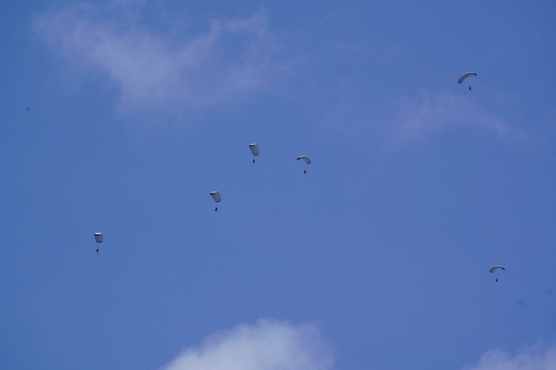 Parajumpers assigned to the U.S. Air Force 31st Rescue Squadron parachute down after deploying from an Air Force 36th Airlift Squadron C-130 Hercules airplane northeast of Pagan in the Commonwealth of the Northern Mariana Islands April 19, 2026. The parajumpers worked alongside the crew of fast response cutter USCGC Frederick Hatch (WPC 1143) and used an underwater remotely operated drone to search the interior of the capsized cargo vessel Mariana. (U.S. Coast Guard photo, courtesy Cutter Frederick Hatch)