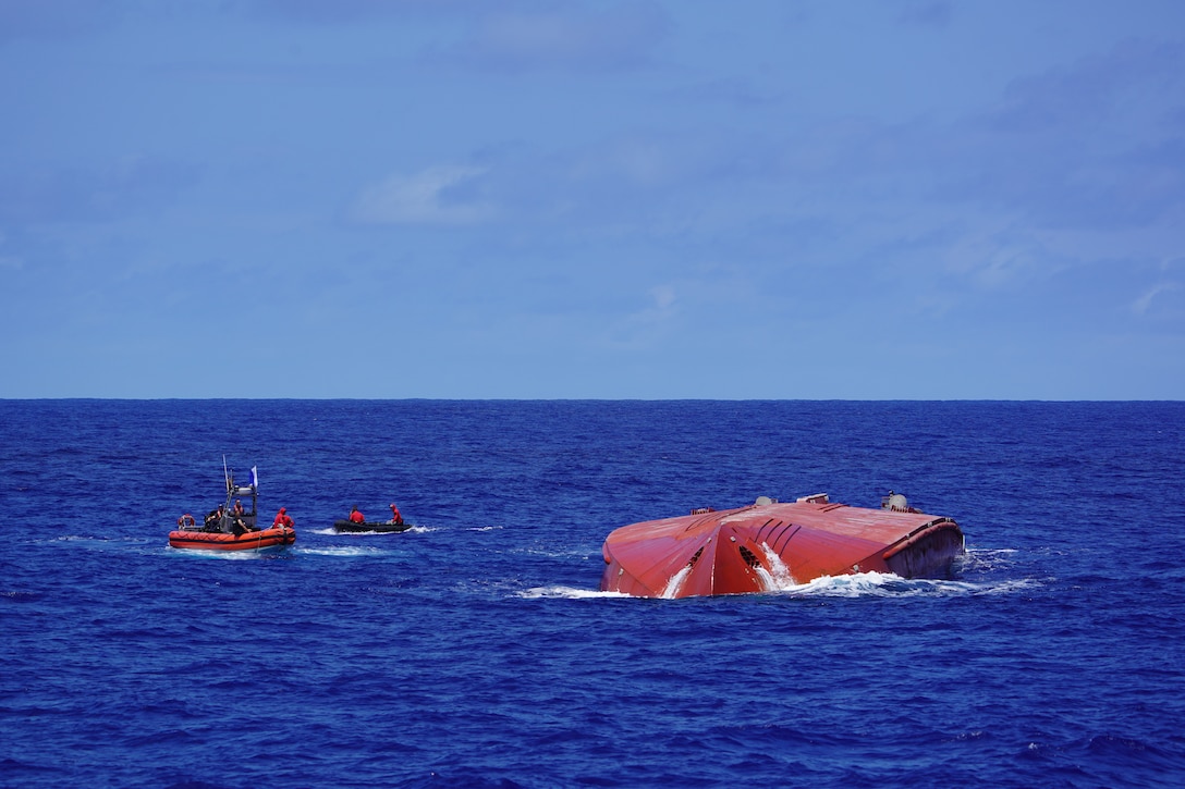 U.S. Coast Guardsmen assigned to the fast response cutter USCGC Frederick Hatch (WPC 1143) and parajumpers assigned to the U.S. Air Force 31st Rescue Squadron assess the scene near a capsized cargo vessel northeast of Pagan in the Commonwealth of the Northern Mariana Islands April 19, 2026. During dive operations, parajumpers conducted a comprehensive subsurface evaluation of the Mariana's exterior and used an underwater remotely operated drone to search the interior of the vessel. (U.S. Coast Guard photo, courtesy Cutter Frederick Hatch)