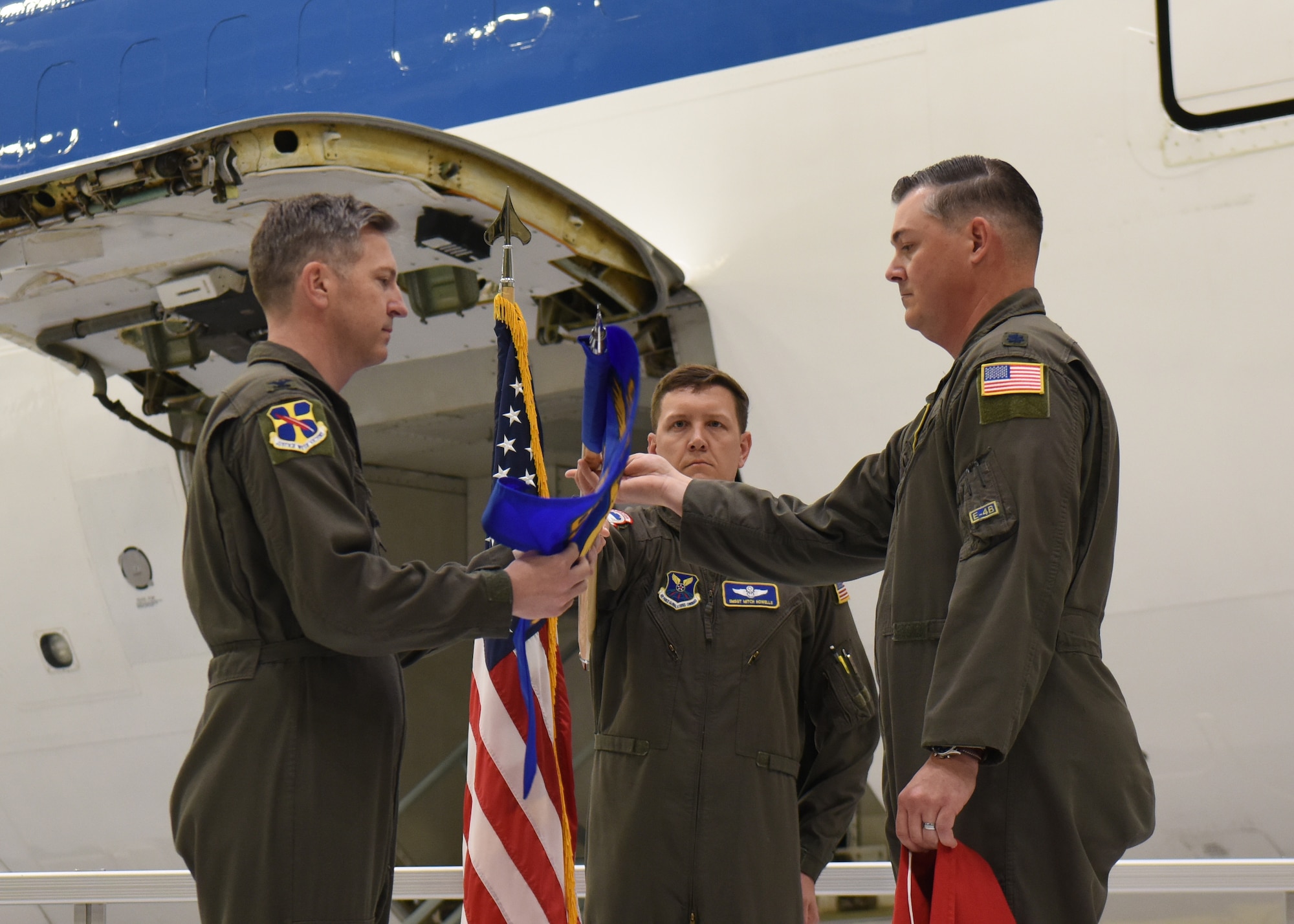 Col. Patrick Hook unfurls the 95th Operations Support Squadron guidon