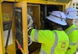 Two soldiers inspect an electrical panel.