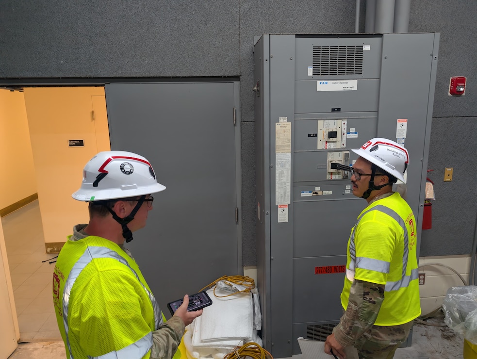 Two soldiers inspect electrical equipment