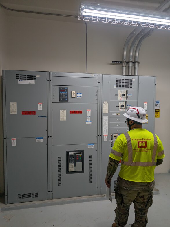A Soldier looks at a large electrical panel