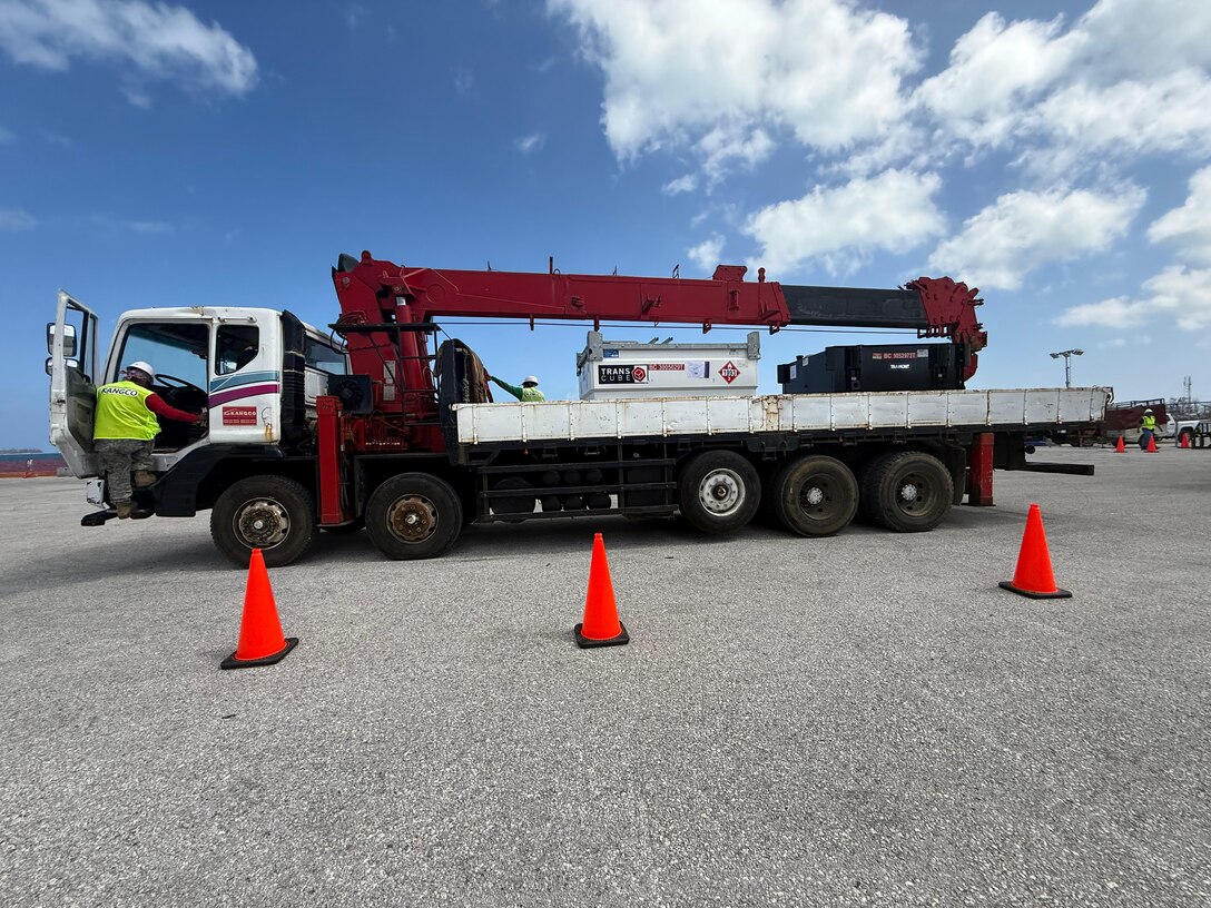 a man is getting into the cab of a large flatbed truck loaded with generators