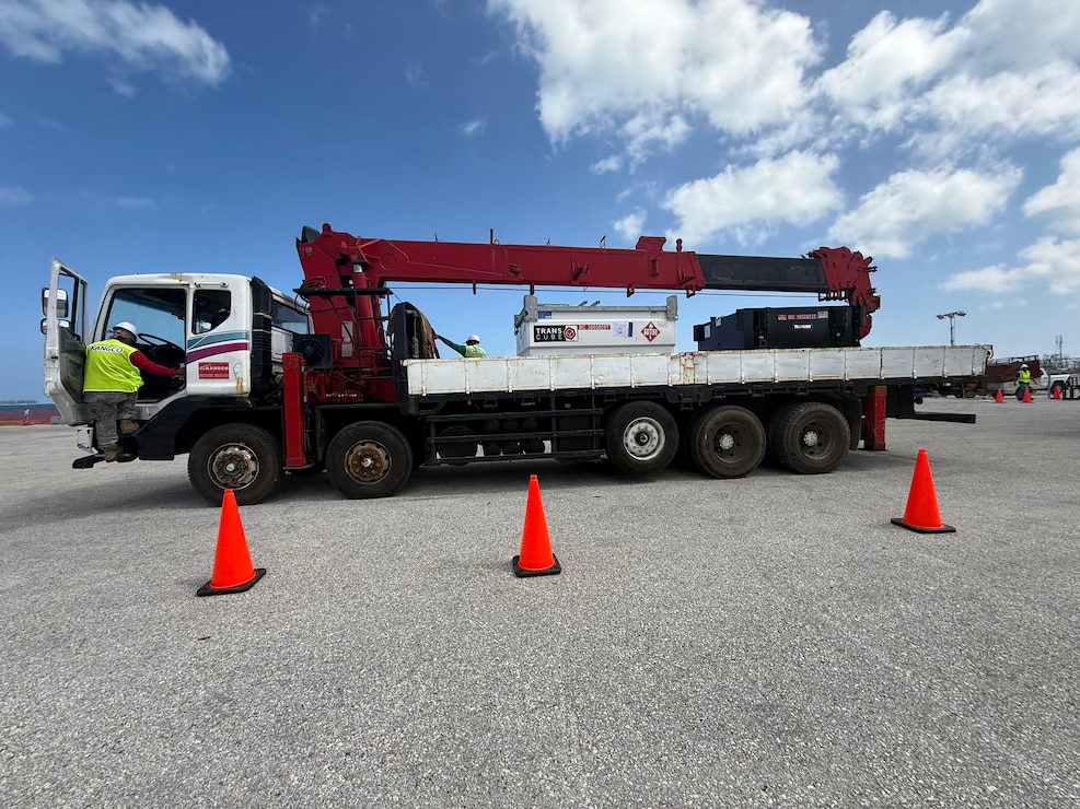 a man is getting into the cab of a large flatbed truck loaded with generators