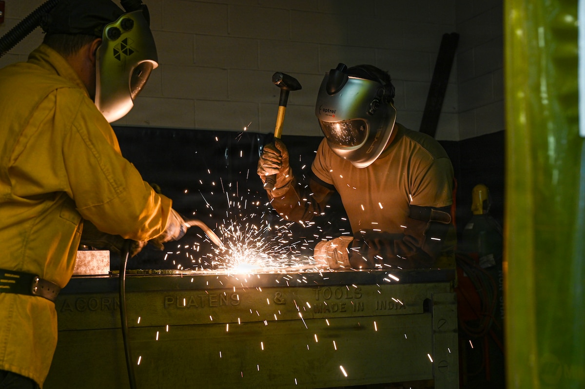 Staff Sgt. Scott Estes and Staff Sgt. Brandon Kennedy, aircraft metals technology technicians with the 113th Maintenance Squadron, weld sheet metal at Joint Base Andrews, Md., March 20, 2026. The metals shop repairs, designs and manufactures aircraft parts and equipment using welding and computer numerical control technology. (U.S. Air National Guard photo by Staff Sgt. Natalie Filzen)