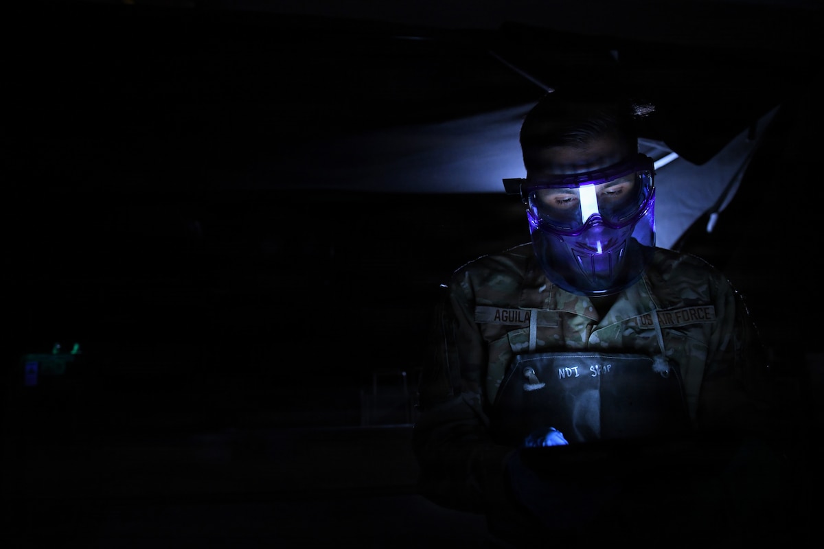 Staff Sgt. Marcos Aguilar, 146th Maintenance Squadron, reads a technical order while conducting magnetic particle inspections on C-130J Super Hercules components at March Air Reserve Base, Calif., April 12, 2026. The inspections identify cracks and ensure parts remain serviceable to prevent potential aircraft failures. (U.S. Air National Guard photo by Senior Master Sgt. Julianne Sitterding)