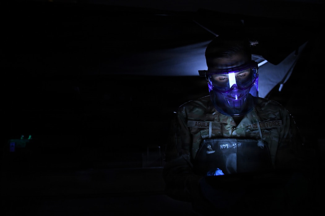 Staff Sgt. Marcos Aguilar, 146th Maintenance Squadron, reads a technical order while conducting magnetic particle inspections on C-130J Super Hercules components at March Air Reserve Base, Calif., April 12, 2026. The inspections identify cracks and ensure parts remain serviceable to prevent potential aircraft failures. (U.S. Air National Guard photo by Senior Master Sgt. Julianne Sitterding)