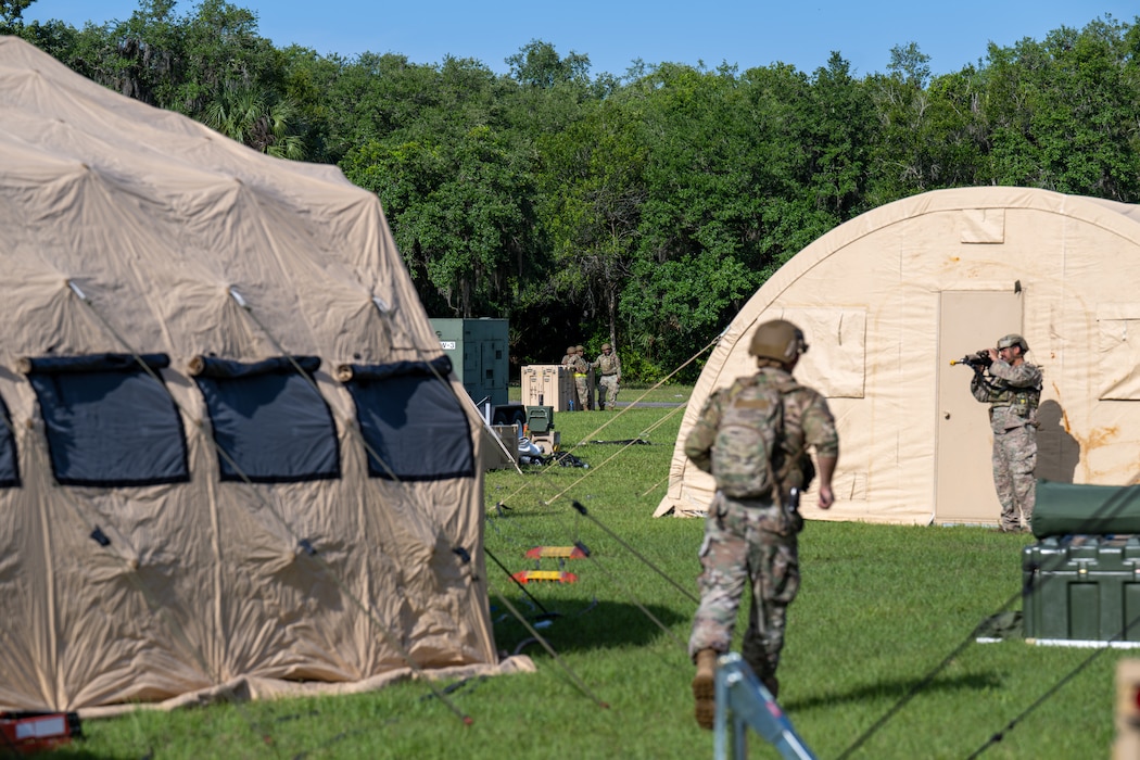 People walk around a camp.