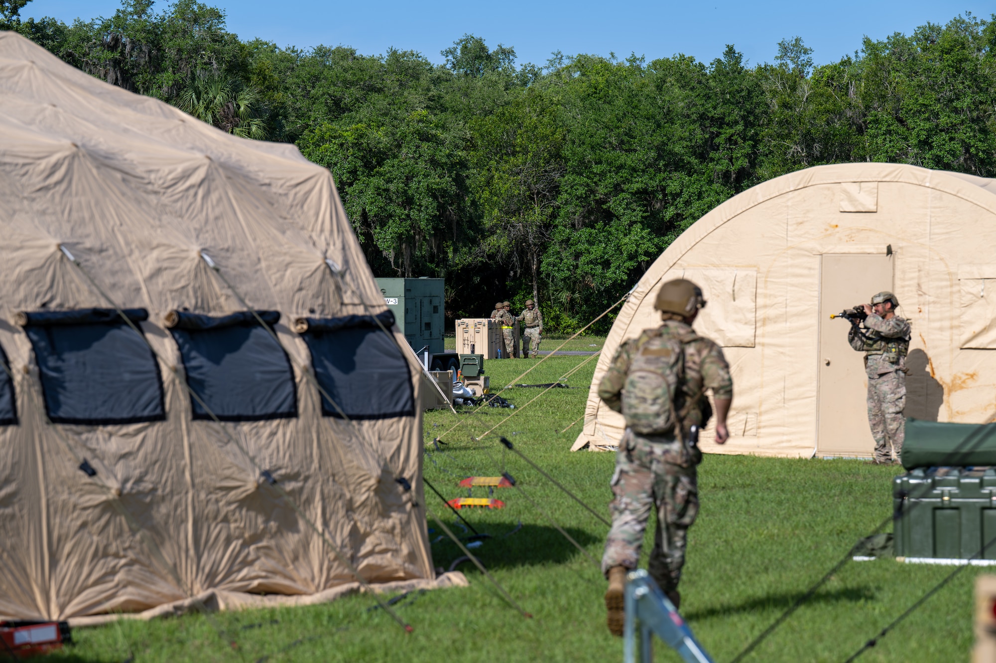 People walk around a camp.