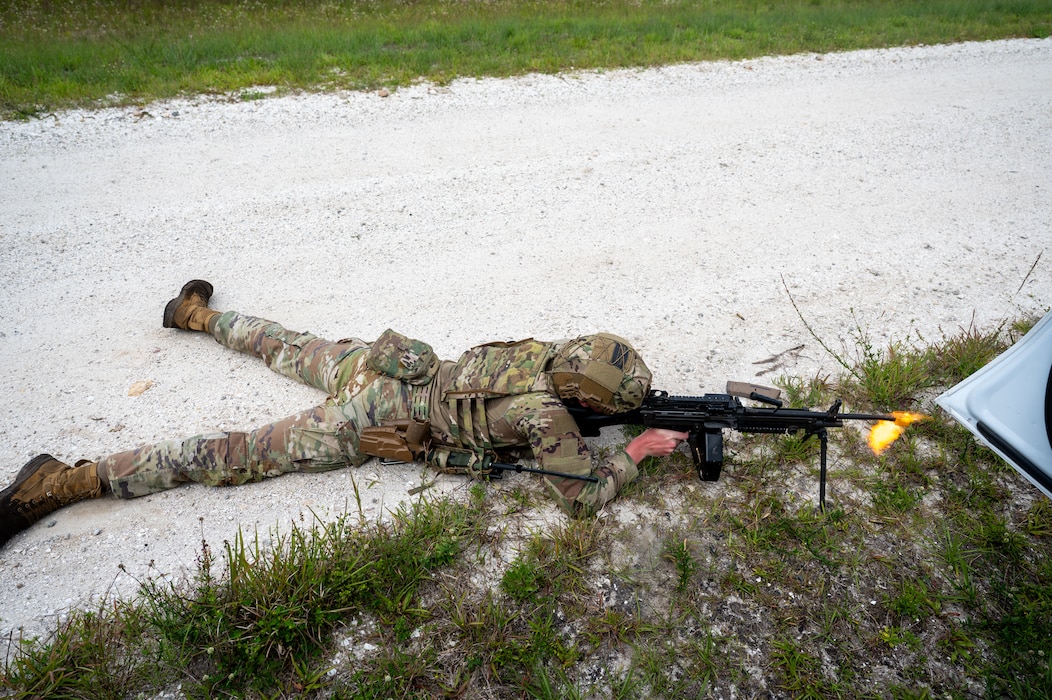 Man lays on ground and fires weapon.