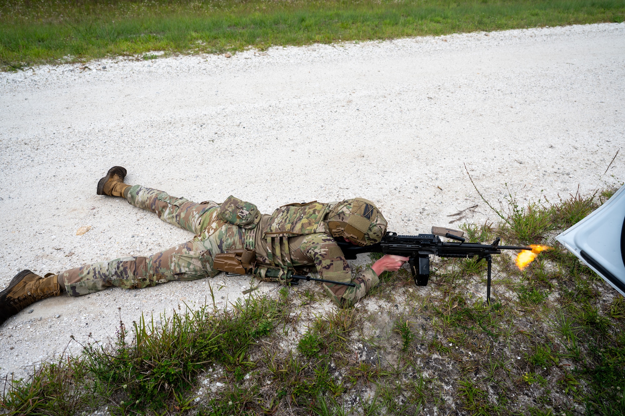 Man lays on ground and fires weapon.