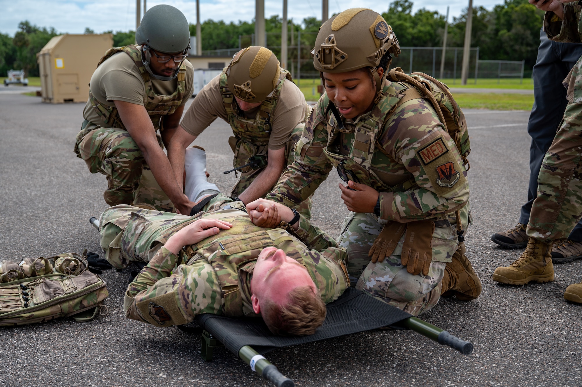 Woman comforts man as he lays on cot.
