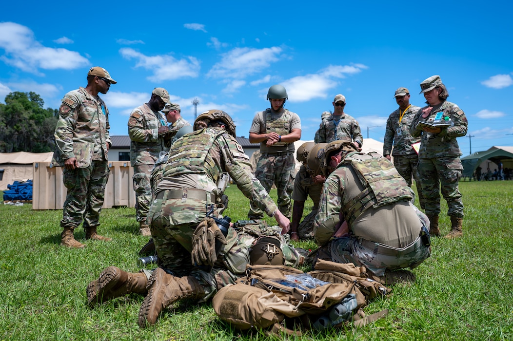 People observe other people tending to a man.