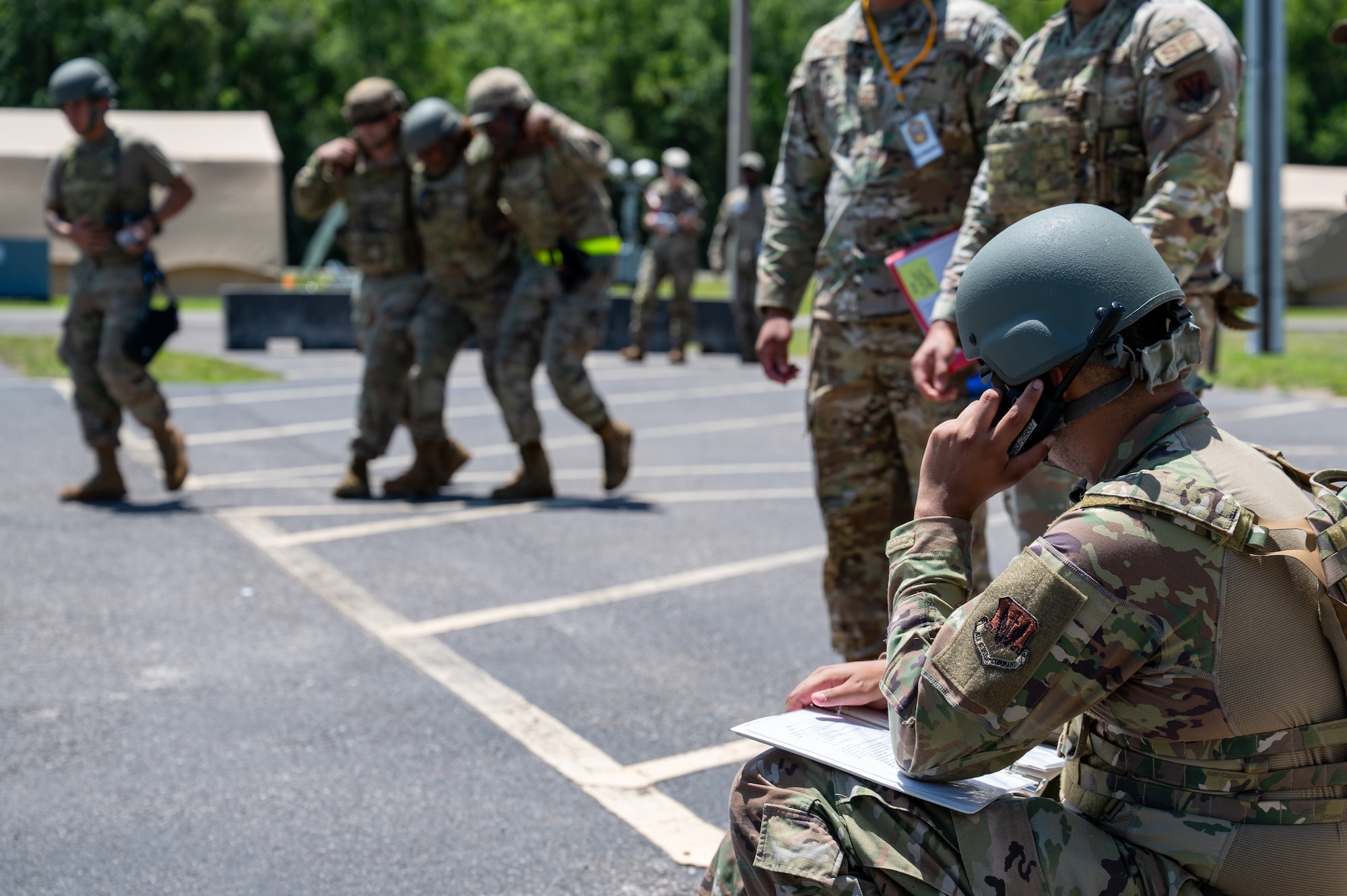 Man sits on radio as people walk.