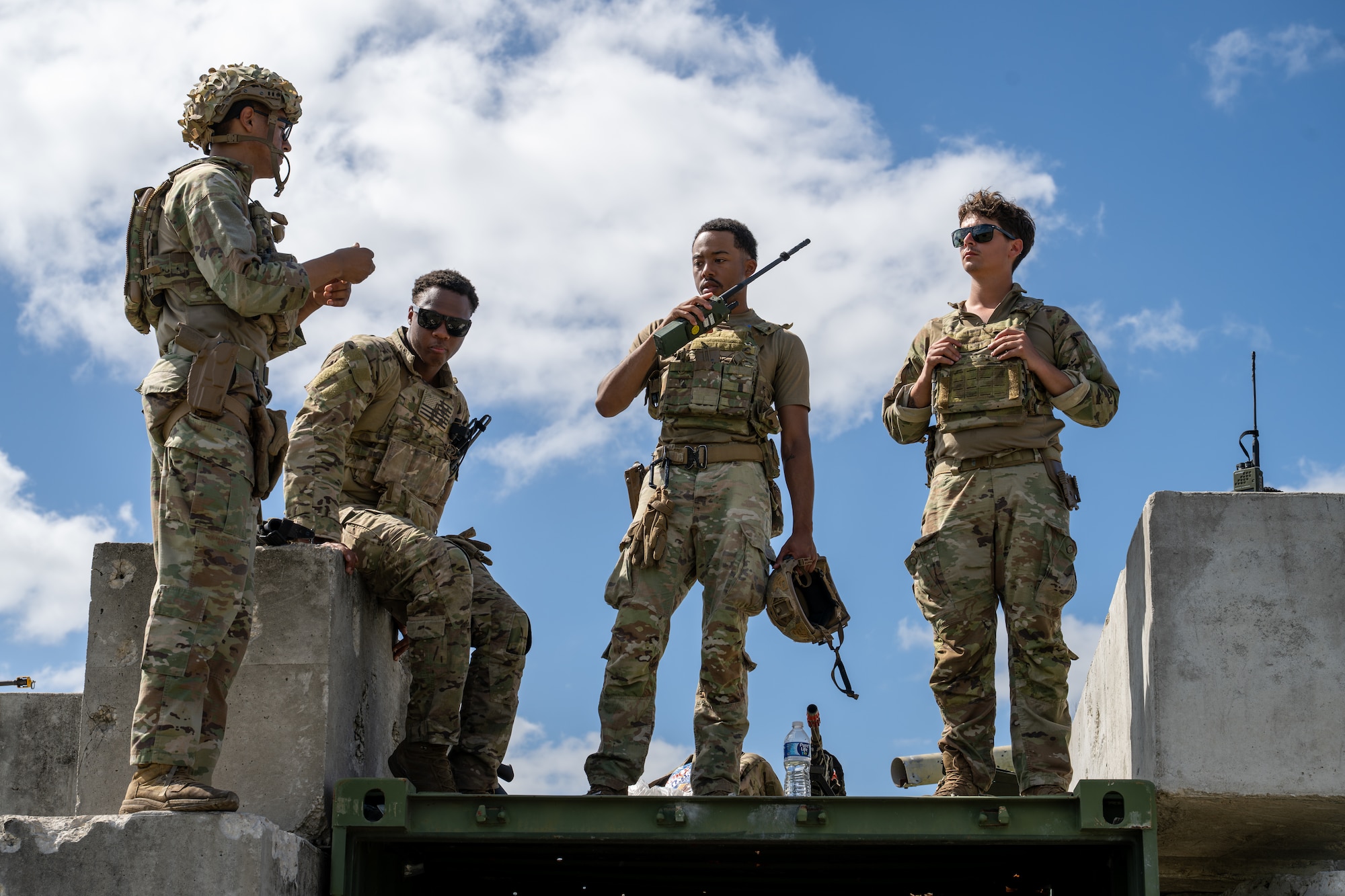 Men stand in a line, talking to each other.