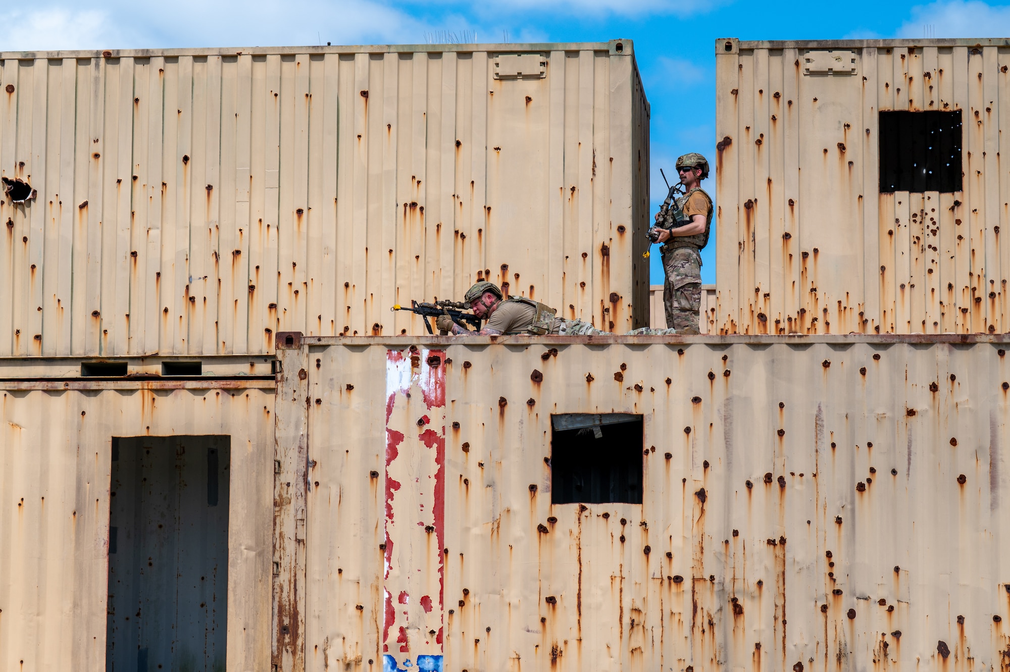 Men observe the area from the top of a building.