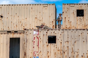 Men observe the area from the top of a building.