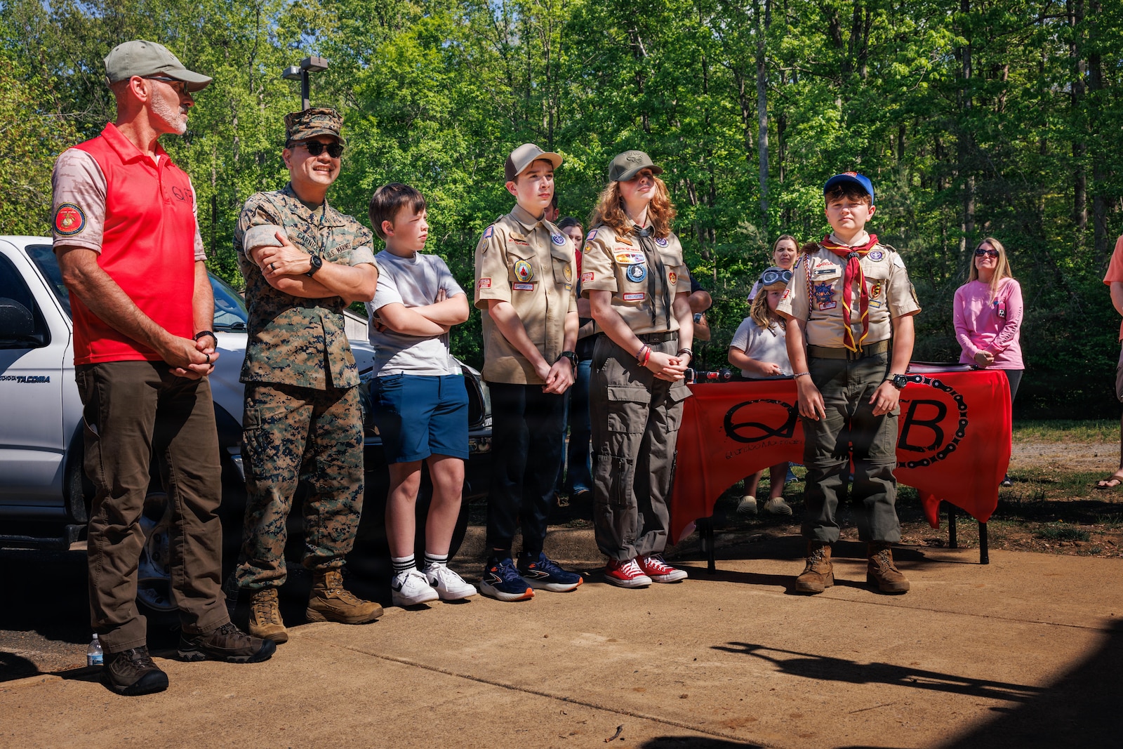 An audience attends Life Scout Santiago Carnice’s, troop 176, dedication ceremony at the Child 
Development Center on Marine Corps Base Quantico, April 17, 2026. Santiago is a 13-year-old scout that 
was honored with a plaque on the newly installed permanent, all-weather bicycle repair station aboard 
MCB Quantico after he received the approval and completion of the project in order to receive his Eagle 
Scout Badge. Santiago contacted the Quantico Mountain Bike Club and presented his project to their 
board and received approval for $3,500 of funding. Santiago and his father worked through Natural 
Resources and Environmental Affairs and base facilities to acquire the permission to dig and secure a 
utilities company site review. The installation enhances trail safety, supports base recreation programs, 
and promotes self-sufficiency for trail users within the Quantico community. (U.S. Marine Corps Photo 
by Cpl. Harleigh Faulk)
