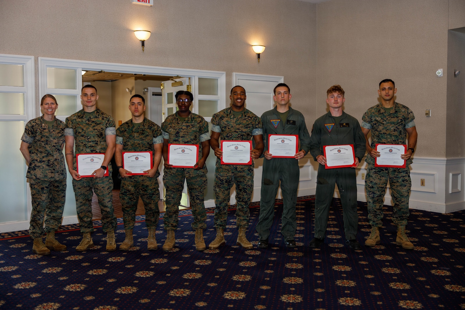 U.S. Marine Corps Col. Jenny Colegate, the commanding officer of Marine Corps Base Quantico, left, poses for a group photo with Marine Corps volunteers of the United Services Organizations, during the Volunteer Appreciation Ceremony at The Clubs at Quantico on MCB Quantico, Virginia, April 22, 2026. The ceremony recognized volunteers who have contributed many hours of valuable service to the Marine Corps or activities benefiting from those services with certificates of appreciation. (U.S. Marine Corps photo by Lance Cpl. Lynsee Avila-Ramirez)