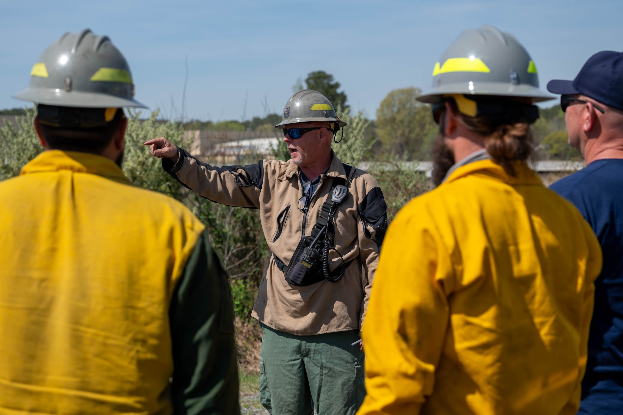 Photos show a man talking as other men stand around him and look towards him.