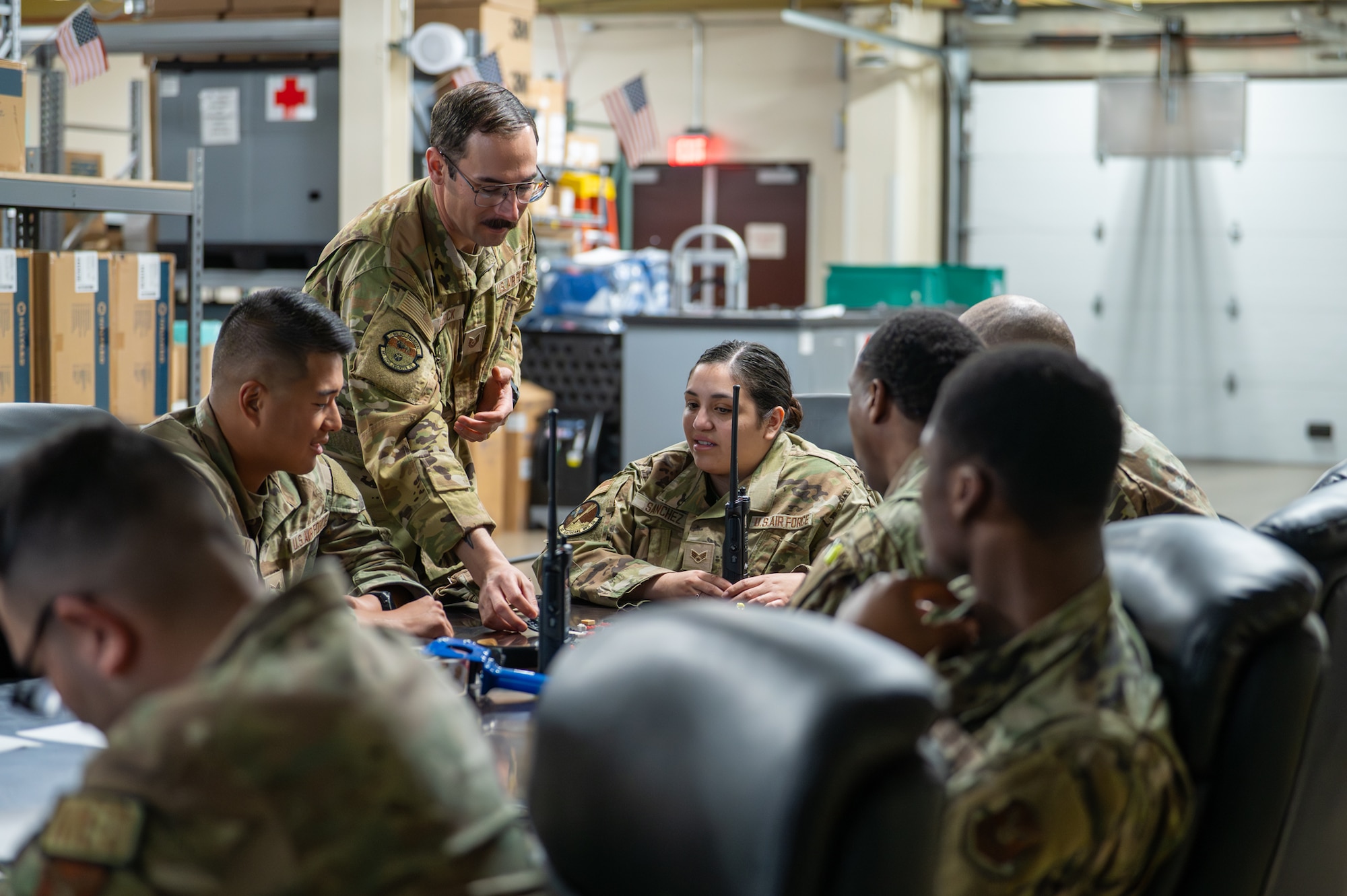 A service member engages directly with the personnel he is instructing during a hands-on radio communications exercise.
