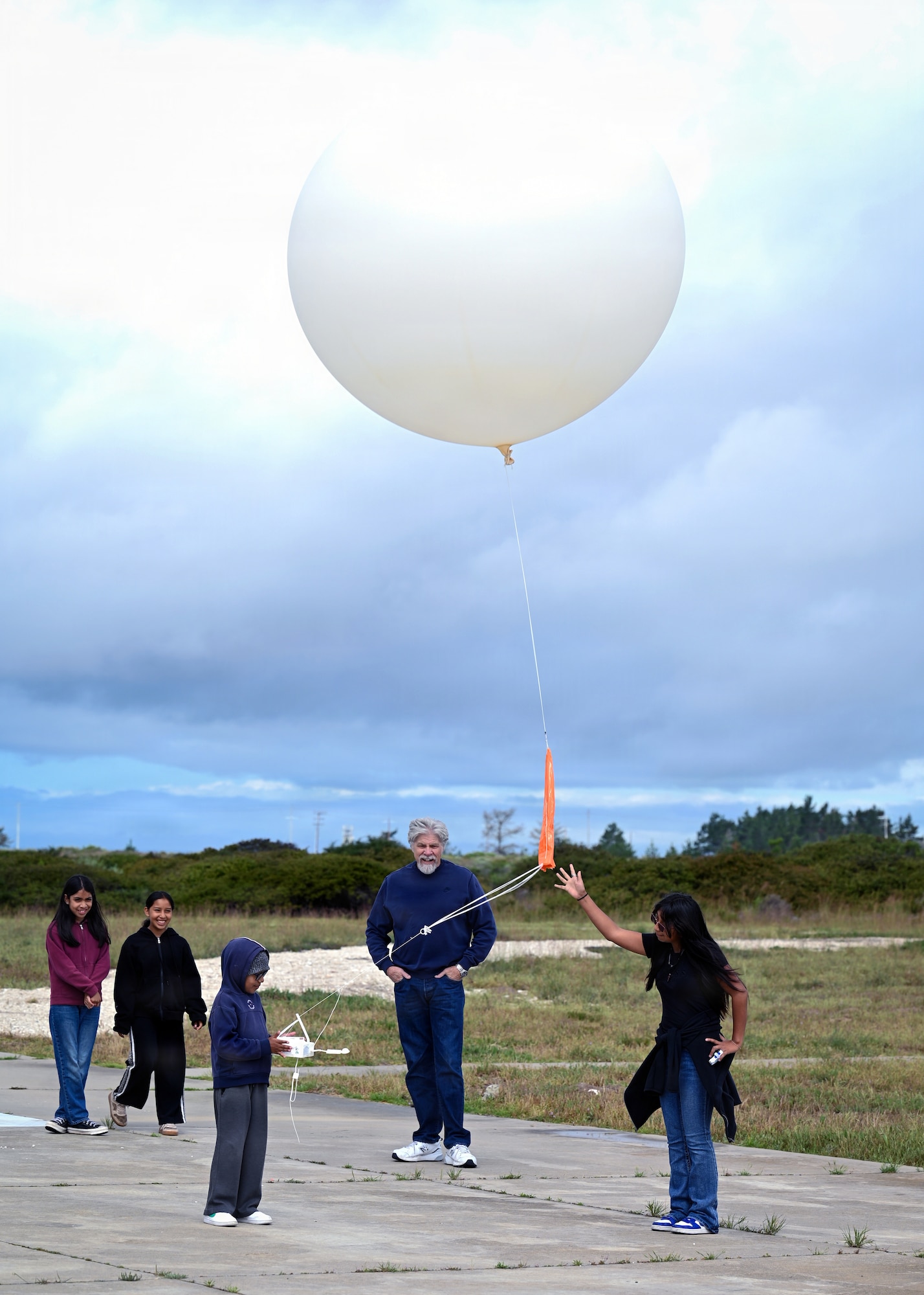 Members of the Boys & Girls Club of Mid Central Coast assist with a weather balloon release.