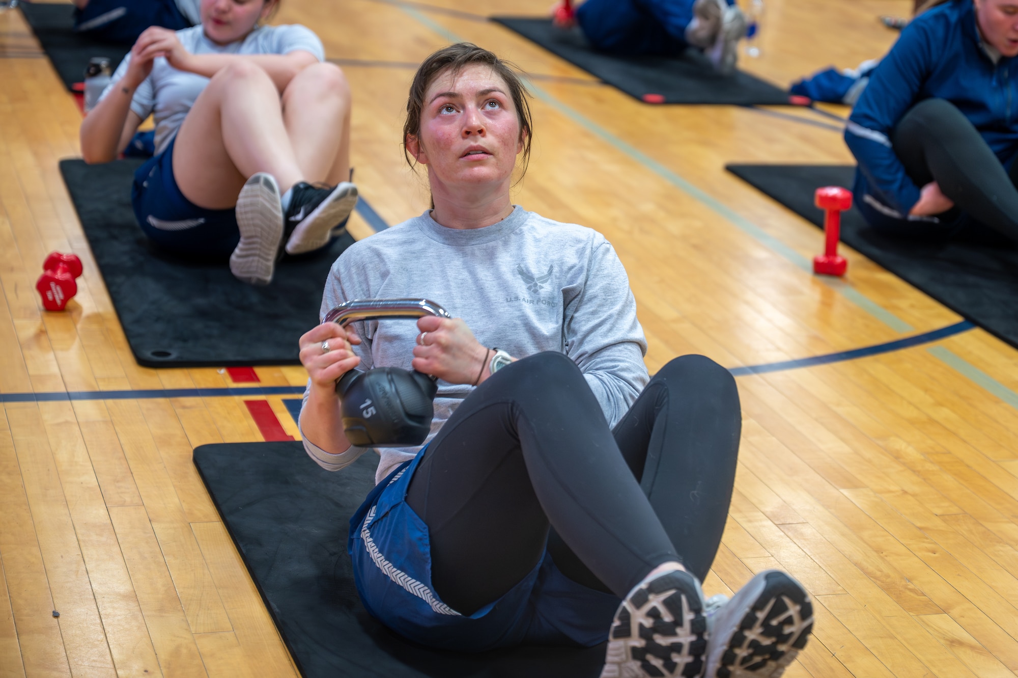 A woman exercises with a kettle bell.