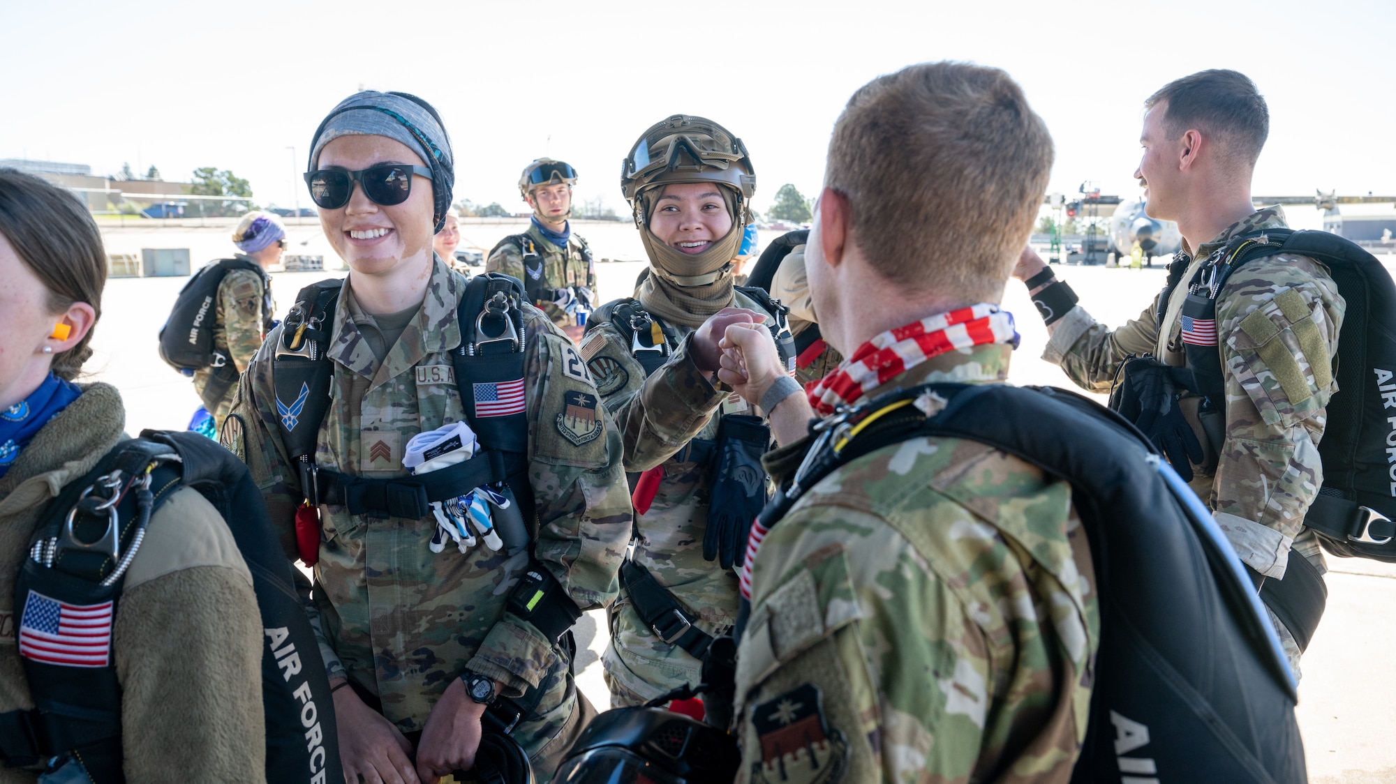 US Air Force Academy cadets fist bump as they load onto a C-130H Hercules aircraft.
