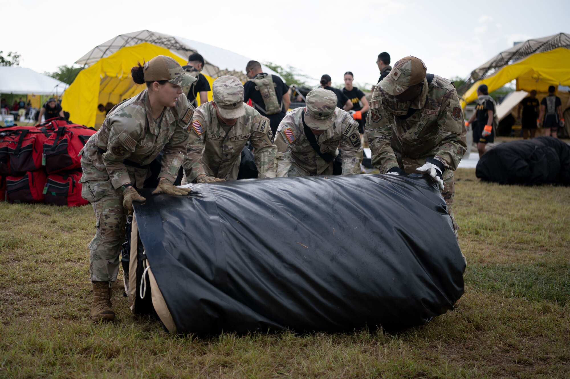 U.S. Airmen and Soldiers assigned to the 22nd CBRN Enhanced Response Force Package, Puerto Rico National Guard, assemble a tent during a Synchronization Collective Training exercise at Camp Santiago Joint Training Center, Salinas, Puerto Rico, March 12, 2026. The exercise immersed teams in high-stress disaster simulations involving search and extraction, decontamination, and medical triage focused on ensuring readiness during domestic operations and future evaluations. (U.S. Air National Guard photo by Master Sgt. Rafael Rosa)