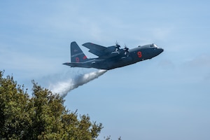 A C-130 plane dropping water.
