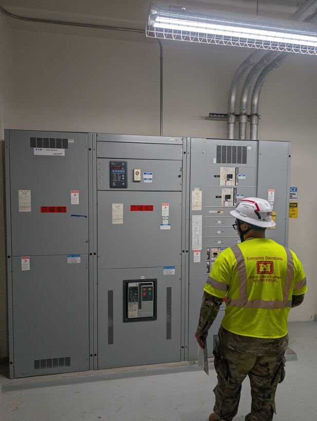 A Soldier looks at a large electrical panel