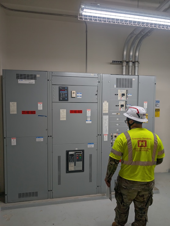 A Soldier looks at a large electrical panel