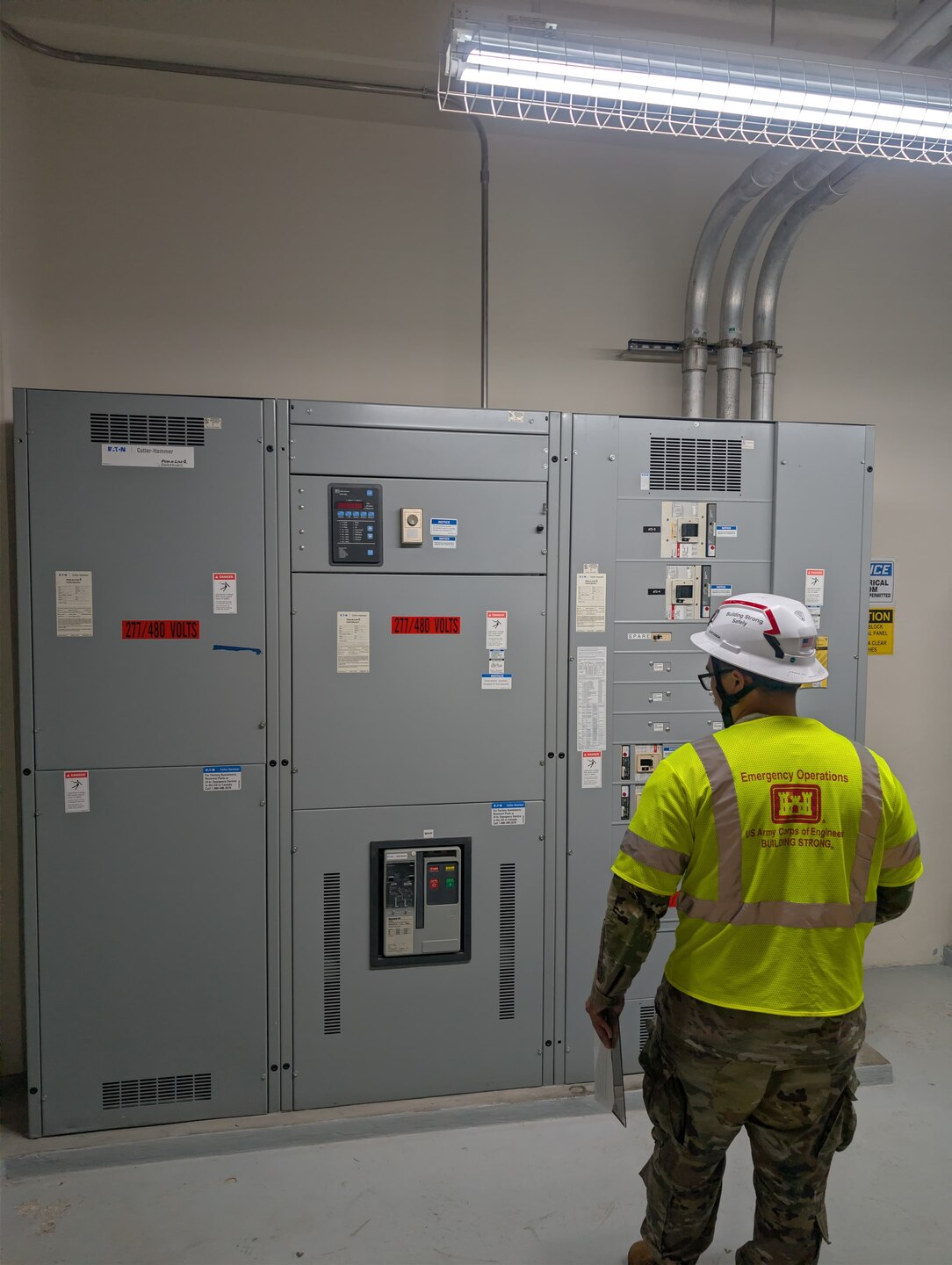 A Soldier looks at a large electrical panel