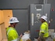 Two soldiers inspect electrical equipment