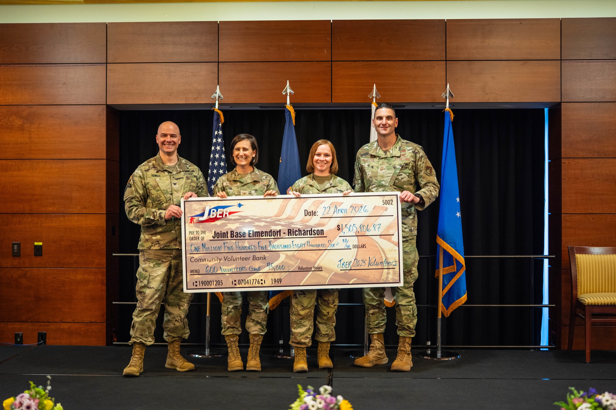 From left: U.S. Army Jimmy Howell, 2nd Airborne Brigade Combat Team, 11th Infantry Division commander, U.S. Air Force Col. Lisa Mabbutt, 673d Air Base Wing and Joint Base Elmendorf-Richardson commander, U.S. Army Spc. Takayla Jackson, 2nd Infantry Brigade Combat Team (Airborne), 11th Airborne Division clerk and U.S. Air Force Chief Master Sgt. Michael Sylvester, 673d ABW command chief, poses with a ceremonial check during the Annual Volunteer Recognition Ceremony at Joint Base Elmendorf-Richardson. The check represents more than $1.5 million in recorded volunteer service hours contributed by service members, families and community partners across the installation. (U.S. Air Force photo by Airman 1st Class Keola Vischi)